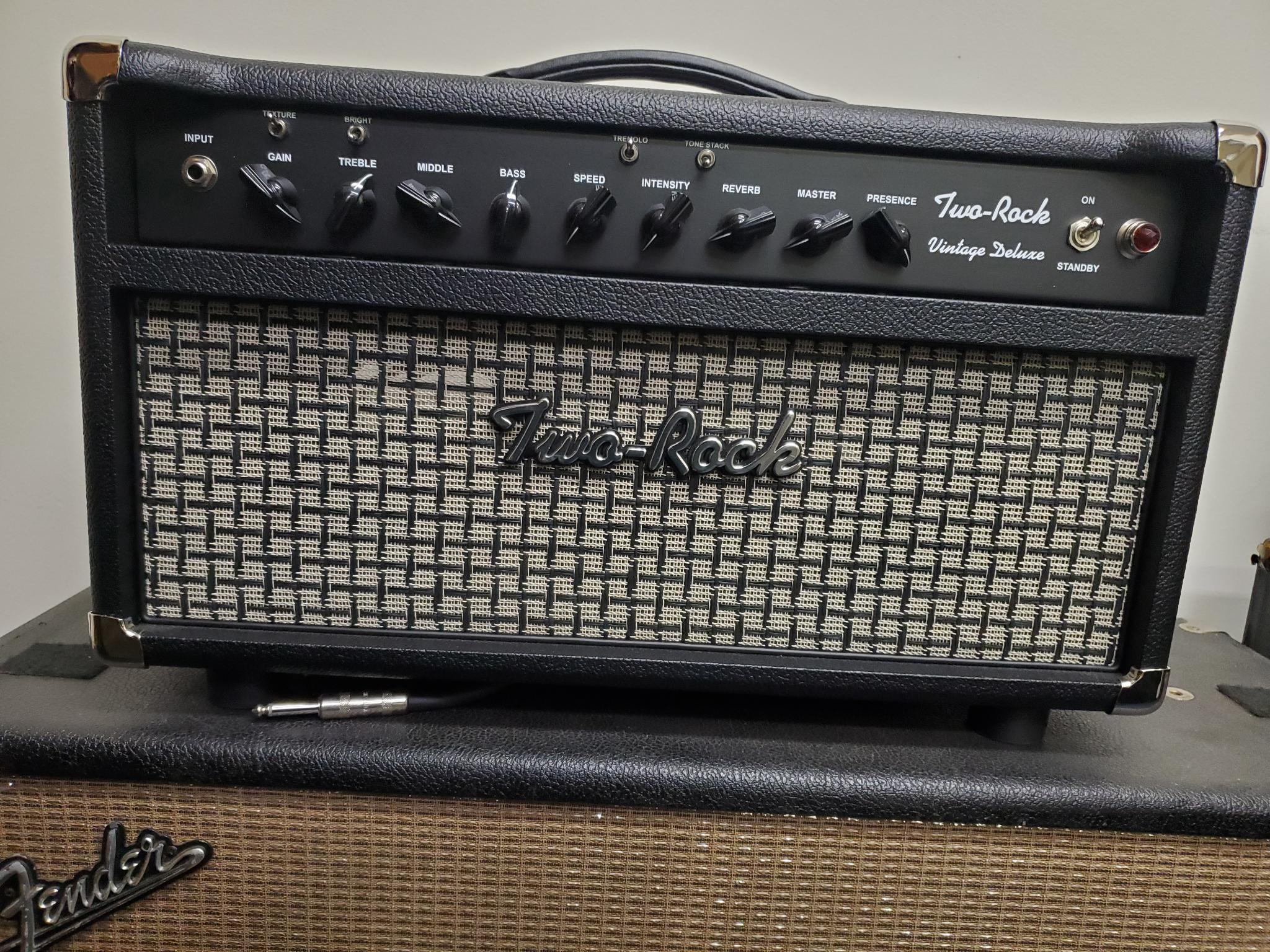 The Vintage Deluxe is a single-channel amp that features lush all-tube analog reverb and a smooth bias tremolo circuit. The Vintage Deluxe utilizes a new texture switch that changes the feel of the amp from a soft scooped front-end to a faster note attack with an increased amount of harmonic content. Another unique feature is the Tone Stack select switch. When engaged via the foot switch or toggle, the tone stack on the front on the amplifier is bypassed and a secondary tone stack with a single Tone control on the back on the amplifier becomes active. This allows you to shape your tone from dark and wooly to a nicely overdriven, organic lead tone.  The Vintage Deluxe gives you that nostalgic feeling from the golden era of tube amplifiers built in the early to mid-sixties, along with all of the performance, trusted reliability, and unique voice that you expect from a Two-Rock.  Head Features:  Single channel, 4 X 6V6, 40 Watts, Switchable to 20 Watts Texture Switch Tone Stack Select Switch bypasses Bass/Middle/Treble controls and engages rear panel single Tone control Tube driven analog Spring Reverb with Send and Return controls Bias Tremolo All steel chassis for vintage vibe, feel and tone, Foot switchable Tone Stack Select and Bias Tremolo 4, 8, 16 ohm output Dimensions: 20 5/8" W x 12" H x 10 5/8 D / Weight: 47 lbs  Tube Compliment V1- Preamp 12AX7 V2- Reverb Drive 12AT7 V3- Reverb Mix 12AX7 V4- Reverb Send, Reverb Stage 1 12AX7  V5- Tremolo Oscillator 12AX7  V6- Phase Splitter 12AX7 V7-V8 – 6V6 Output